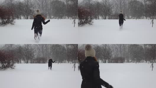 女人高高兴兴地跑上厚厚的毛绒绒的雪，雪花飘舞的慢动作高清在线视频素材下载