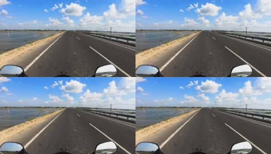 摩托车行驶在柏油路上，有令人惊叹的蓝天和白云高清在线视频素材下载