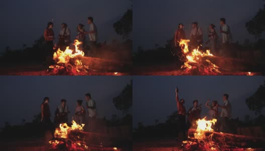 朋友们在野外露营时，在火边跳舞、弹吉他。高清在线视频素材下载