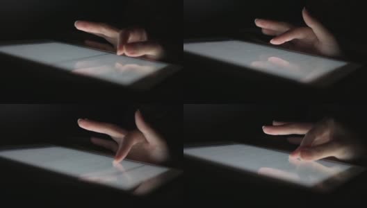 在床上睡觉前，一名女性在不开灯的情况下，手指滑过平板电脑屏幕玩社交媒体。高清在线视频素材下载