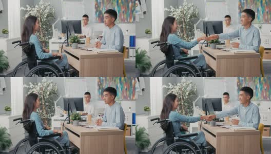 一名女子坐在轮椅上，坐在办公室的办公桌前，对面她的雇主伸出手，他们握手感谢对方的面试祝贺问候说再见高清在线视频素材下载