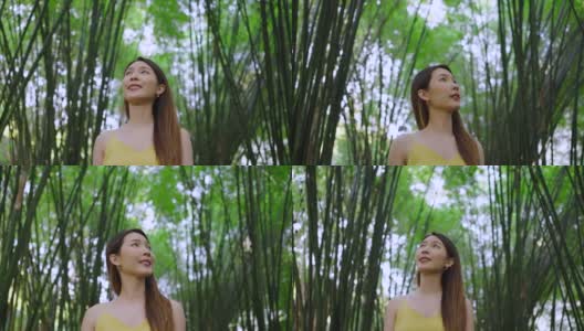 快乐的亚洲女人走在美丽的竹林下。女性旅游生态旅游高清在线视频素材下载