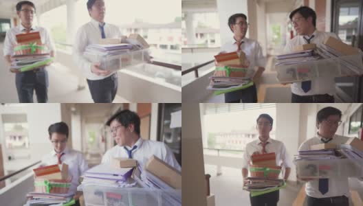 两个亚洲商人提着办公用品箱一起走高清在线视频素材下载