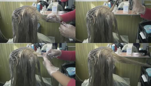 一个年轻女孩梳头前在美容沙龙绘画的特写高清在线视频素材下载