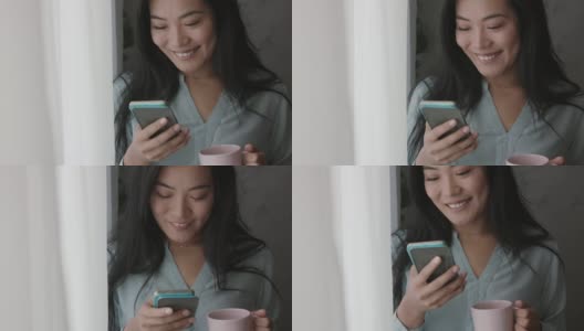 年轻的亚洲女人给朋友发短信，看着窗外，喝着咖啡高清在线视频素材下载