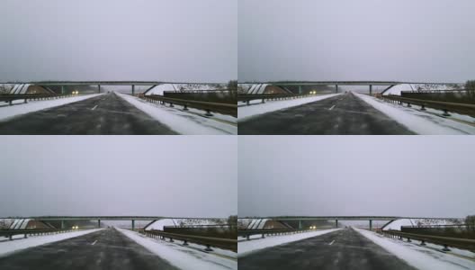 在可怕的多雪多风的天气里，重型货车在公路上行驶。透过挡风玻璃的视野-驾驶员视角。移动视频。高清在线视频素材下载
