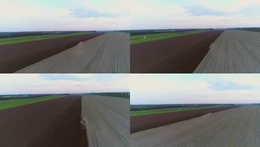 4K无人机航拍镜头。拖拉机耕地。以train为背景高清在线视频素材下载