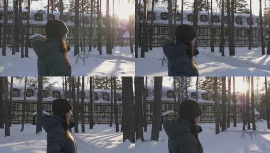 一个年轻女子走在冬天的村舍里，周围是桦树和松树。太阳闪耀光芒。高清在线视频素材下载