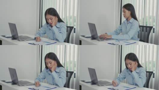 年轻的亚洲女性对工作感到厌烦，觉得在下午处理笔记本电脑上的数据很懒。高清在线视频素材下载