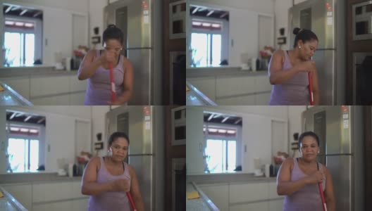 一个成熟女人在家打扫厨房的肖像高清在线视频素材下载