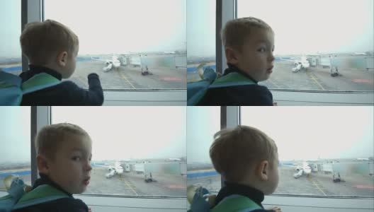 小男孩望着窗外，指着飞机高清在线视频素材下载