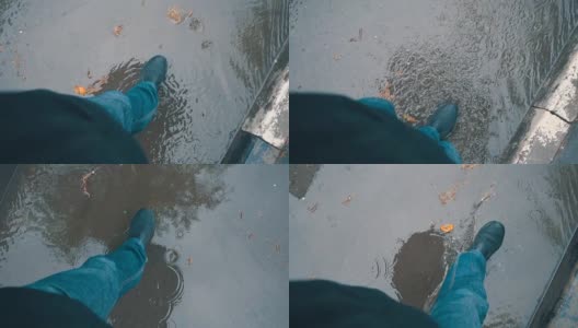 一个男人撑着伞走过雨中的水坑。莫慢，莫慢高清在线视频素材下载