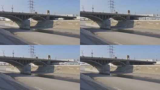 在蓝天阳光明媚的日子里，一辆大型货运火车慢镜头驶过洛杉矶河高清在线视频素材下载