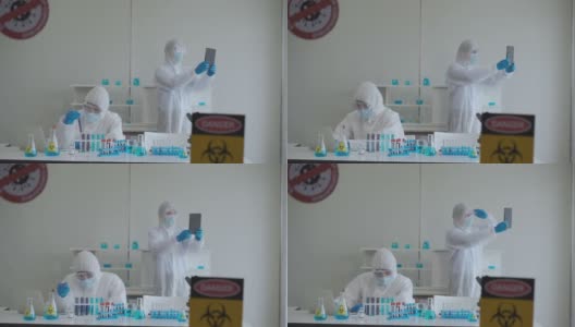 科学家在防护服和防护面罩使用平板电脑视频会议。高清在线视频素材下载