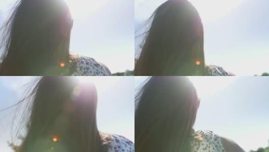 一个女孩的肖像，长发在夏天的风中飘动。后置摄像头。高清在线视频素材下载