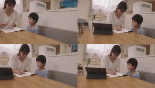 母亲在家工作并帮助儿子做作业高清在线视频素材下载