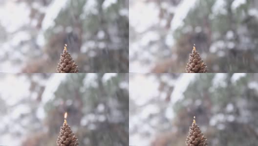 窗外的第一场雪。一根小蜡烛在雪花的背景下燃烧高清在线视频素材下载
