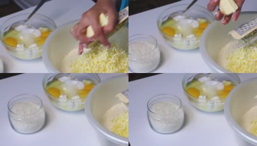 一位妇女在混合配料，准备做大理石蛋糕。用磨粉器把黄油磨成面团。桌子旁边是其他的食材。高清在线视频素材下载