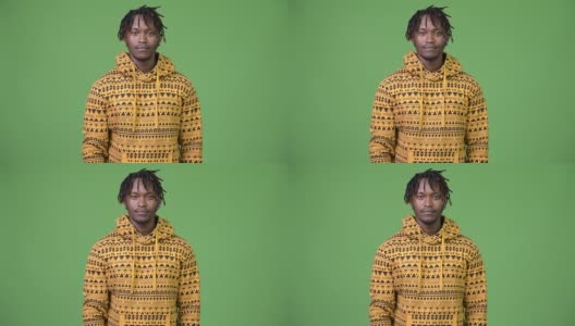 年轻英俊的非洲男子在绿色背景下高清在线视频素材下载