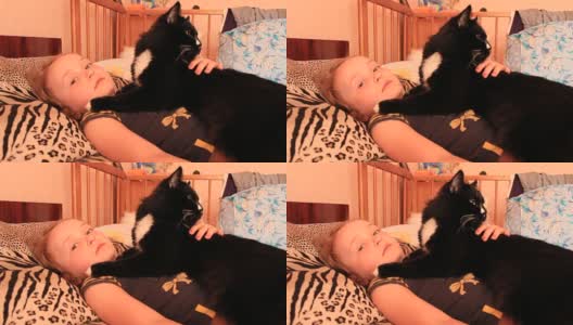 小女孩和她的猫一起躺在床上。和你的宠物一起高清在线视频素材下载