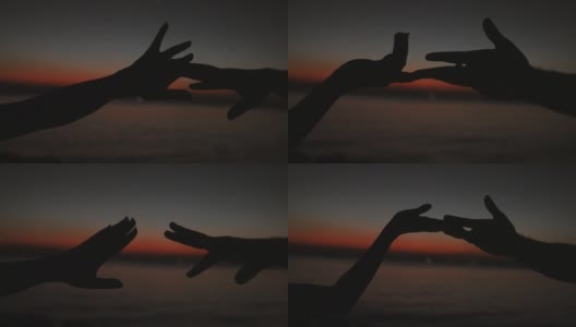手在夕阳的天空下跳舞。海景浪漫高清在线视频素材下载