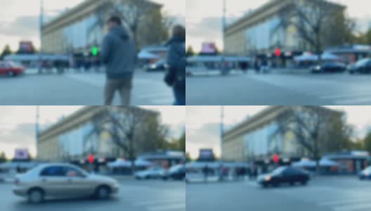 城市场景的模糊镜头:人们在有红绿灯的人行横道上过马路高清在线视频素材下载