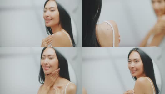 美丽的亚洲女人触摸她的完美柔软的肩膀，脖子，在镜子里性感的微笑。快乐的女性享受她的美丽。健康天然化妆品护肤品。聚焦肖像高清在线视频素材下载