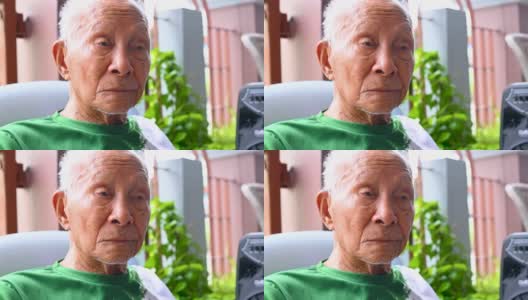 一个九十多岁的亚洲人坐在家里，在他的辛苦工作中放松他的一生。高清在线视频素材下载