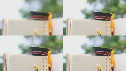毕业或毕业后出国留学的国际概念，祝贺毕业生帽子上的笔记本用铅笔为拷贝空间。学习通向成功的目标生活。回到学校高清在线视频素材下载