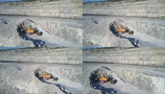 鸟瞰图挖掘机在石棉坑中挖掘灰色土丘高清在线视频素材下载