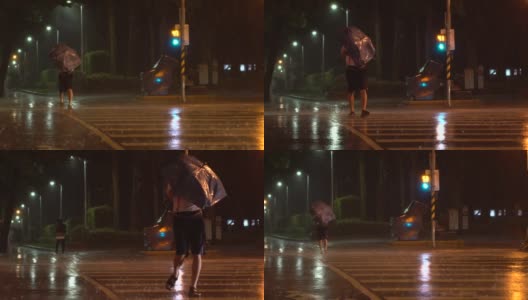 台风台湾期间，行人撑着雨伞挣扎着穿过街道高清在线视频素材下载