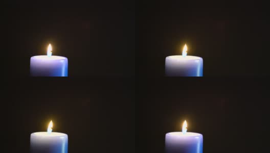 一支巨大的蓝色蜡烛在一片漆黑中燃烧。高清在线视频素材下载