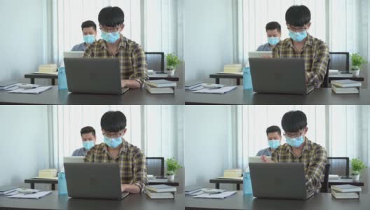 两名商人戴着防护口罩和同事在办公室使用酒精凝胶洗手液的4k视频高清在线视频素材下载