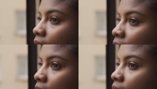 近距离的肖像，迷人的非洲裔美国妇女的眼睛看着窗外。高清在线视频素材下载