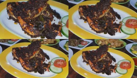 美味的印尼海鲜蟹菜，用香料和调味汁包在芭蕉叶盘里，与印尼餐厅的其他背景菜一起烹制高清在线视频素材下载