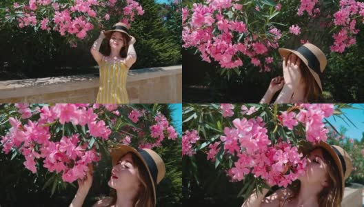 一个戴着帽子的漂亮女人，在花园里闻着粉红色的花，微笑着高清在线视频素材下载