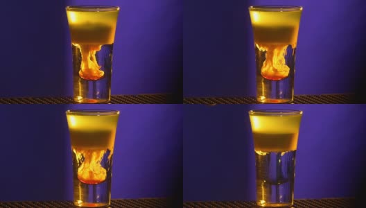 调酒师的双手继续制作鸡尾酒，将红色糖浆加入蓝色，小杯，慢动作高清在线视频素材下载