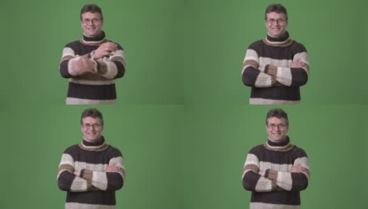 成熟英俊的男人穿着高领毛衣对绿色的背景高清在线视频素材下载