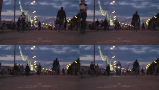 夏夜城市公园理念与健康生活方式。红色的晚霞。在日落天空背景下漫步的人们的剪影。骑自行车、溜冰和玩滑板的人经过。低角度的观点高清在线视频素材下载
