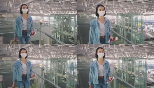 新冠肺炎疫情期间，佩戴口罩的女乘客在机场航站楼走向登机口，以防止感染新冠肺炎。飞机运输的新常态生活理念。高清在线视频素材下载