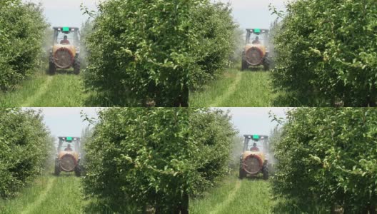 拖拉机向苹果园喷洒的慢动作视频高清在线视频素材下载