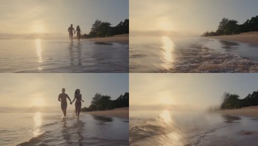 年轻的亚洲情侣在沙滩上散步和跑步。日落剪影橙光看起来很美。高清在线视频素材下载