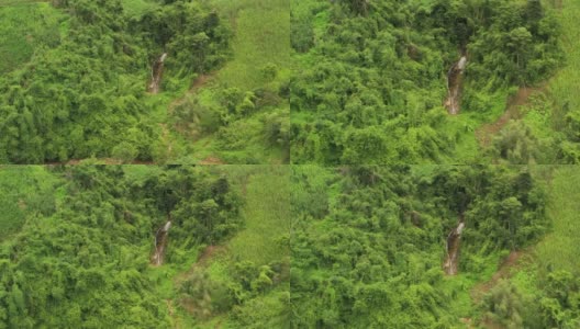 鸟瞰图小瀑布流经常绿森林的岩石悬崖。泰国北部高清在线视频素材下载