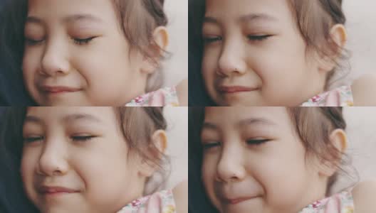 脸近4K可爱的5岁亚洲女孩在妈妈的怀抱中哭泣，透过她的眼睛向人们表达悲伤、不快乐、沮丧和悲伤的情绪。高清在线视频素材下载