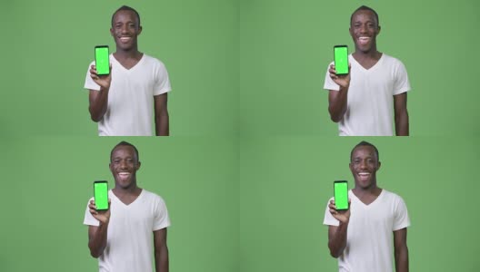 年轻快乐的非洲男子微笑着向镜头展示手机高清在线视频素材下载