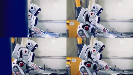机器人焊接一个大的金属板，侧视图。工厂机器人在工作时使用焊接设备。高清在线视频素材下载