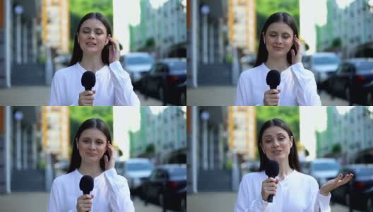 女记者戴着耳机用麦克风对着镜头讲话，现场直播每日新闻高清在线视频素材下载