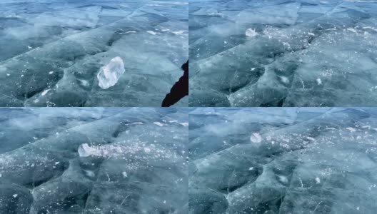 慢动作视频-一个人在贝加尔湖光滑透明的蓝色冰上打碎一块冰。高清在线视频素材下载