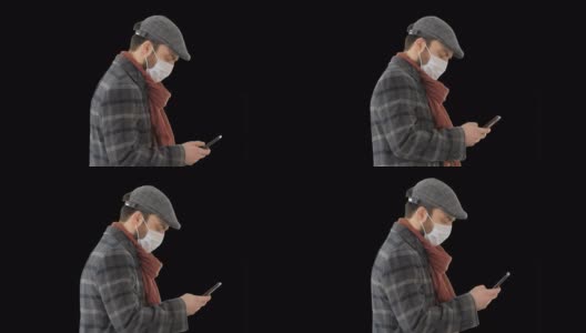 带着医用口罩走路用智能手机的时尚男士，阿尔法频道高清在线视频素材下载