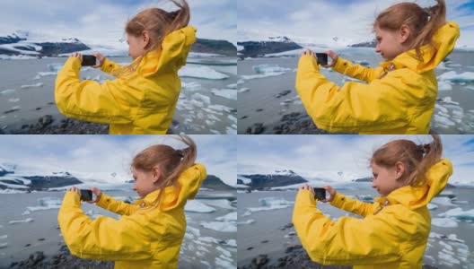 在一个刮风的日子里，一名妇女在冰川泻湖上拍摄漂浮的冰山高清在线视频素材下载